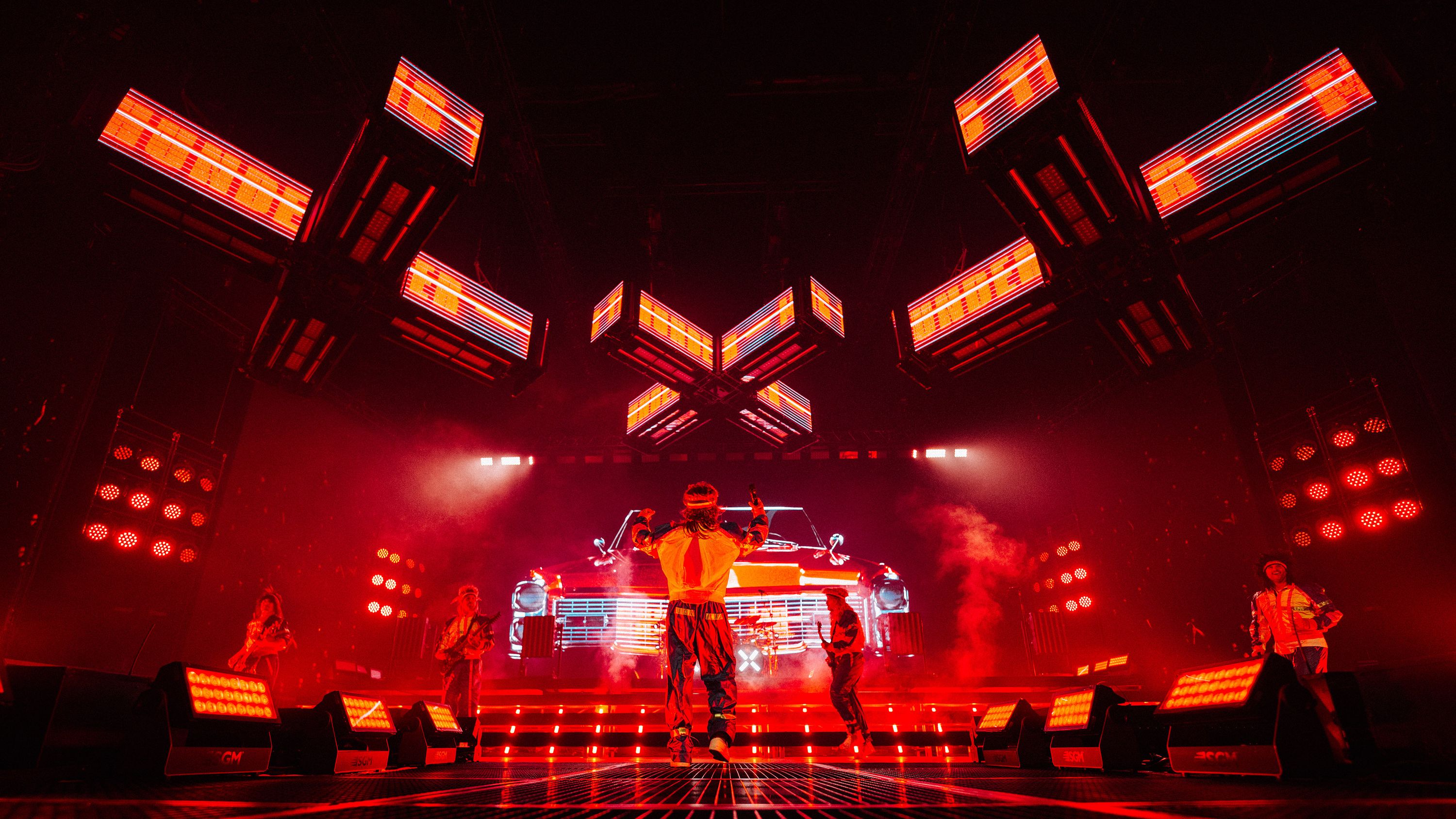 Electric Callboy Tanzneid Arena-Tour: Bühne in rotem Licht mit LED-Wand und Lichtrig