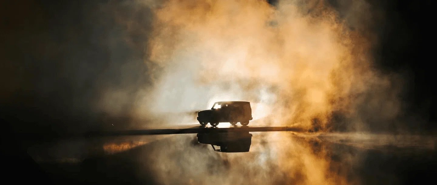 Mercedes-Benz G 580 in fog and golden backlight on a reflective floor