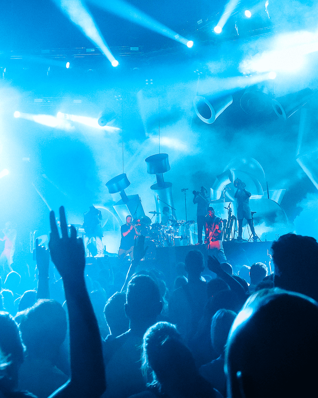 Querbeat live: crowd with raised hands in blue stage light