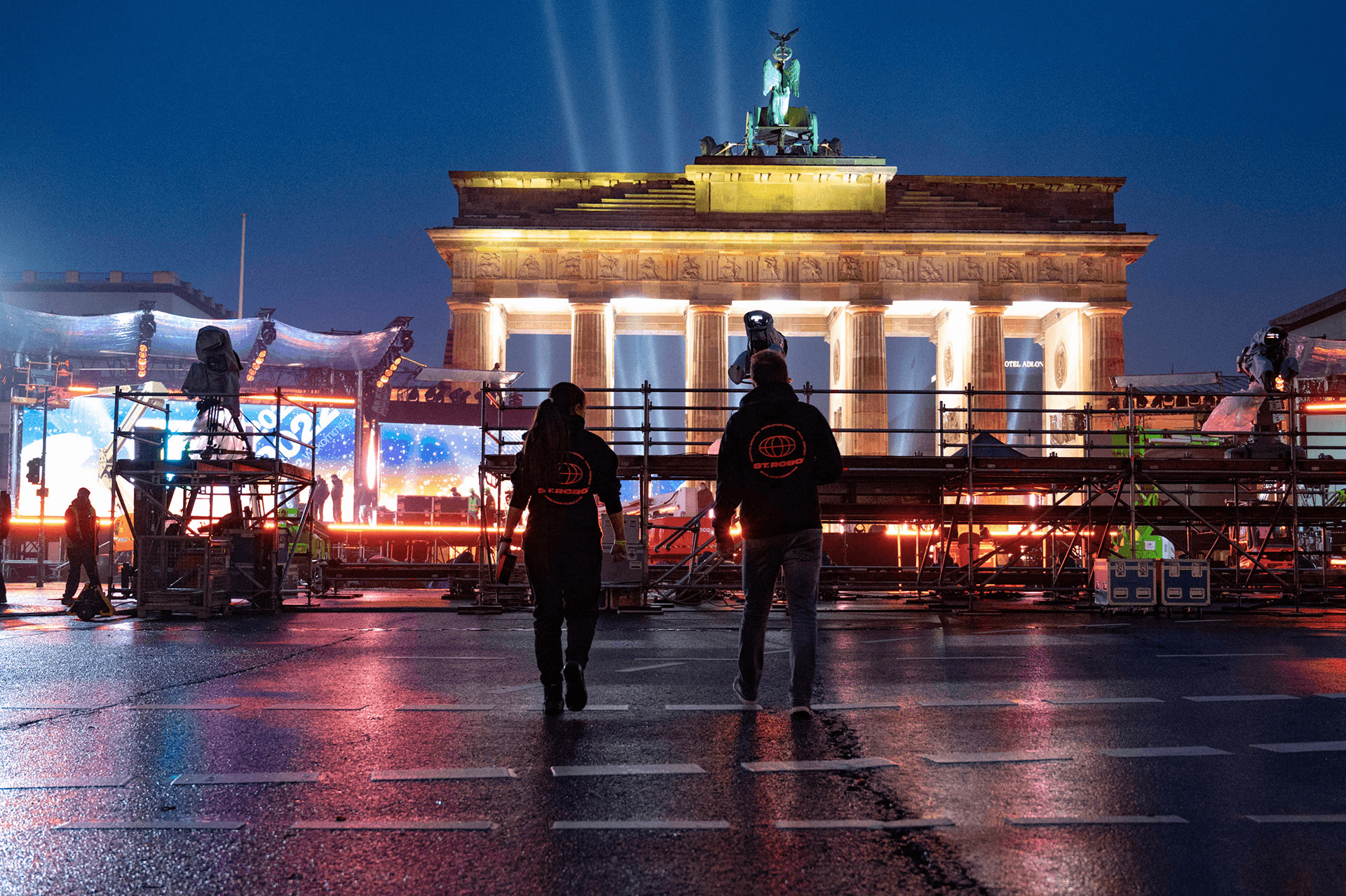Crew in front of the illuminated Brandenburg Gate at night