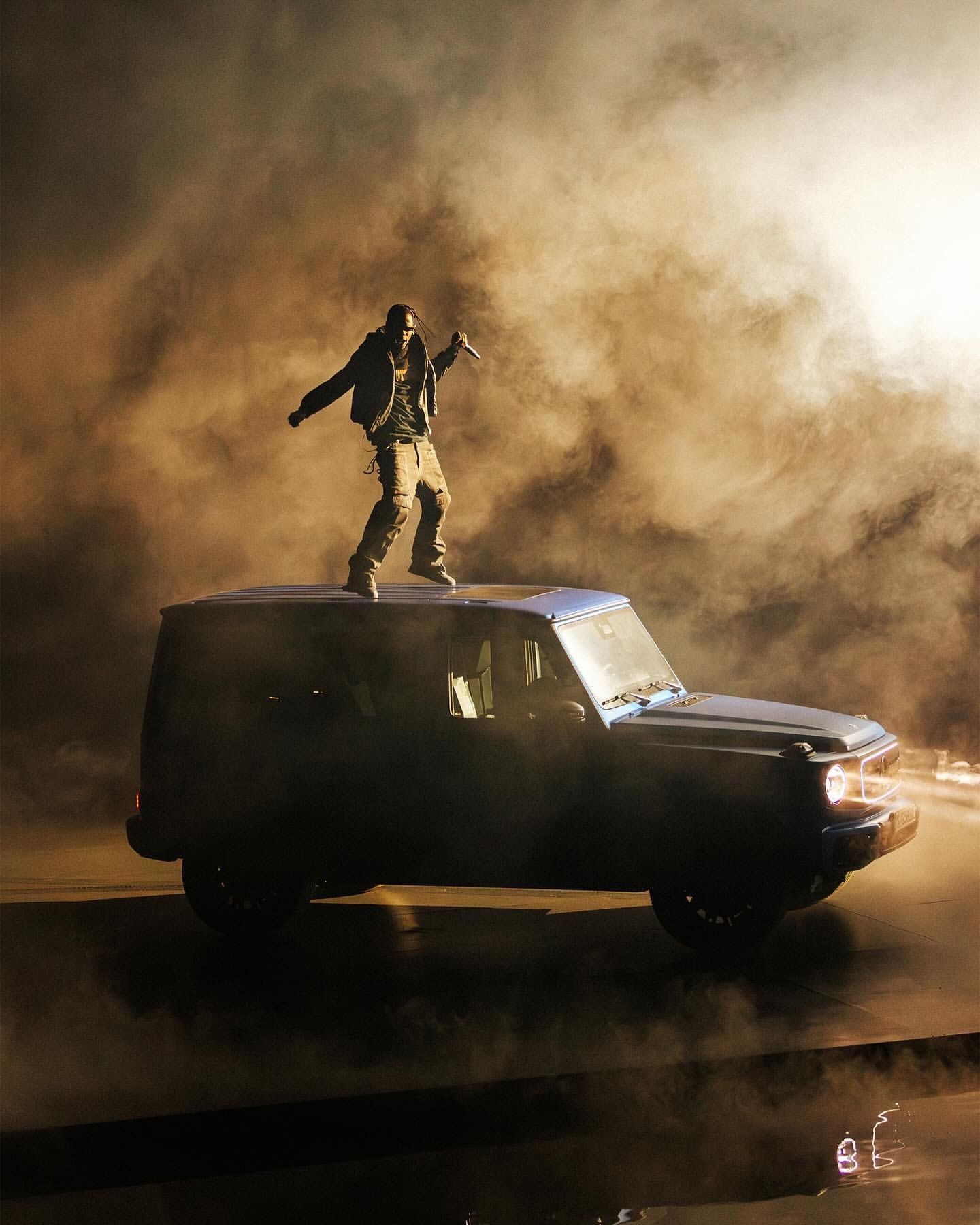 Travis Scott auf dem Mercedes-Benz G 580 in goldenem Staub und Gegenlicht