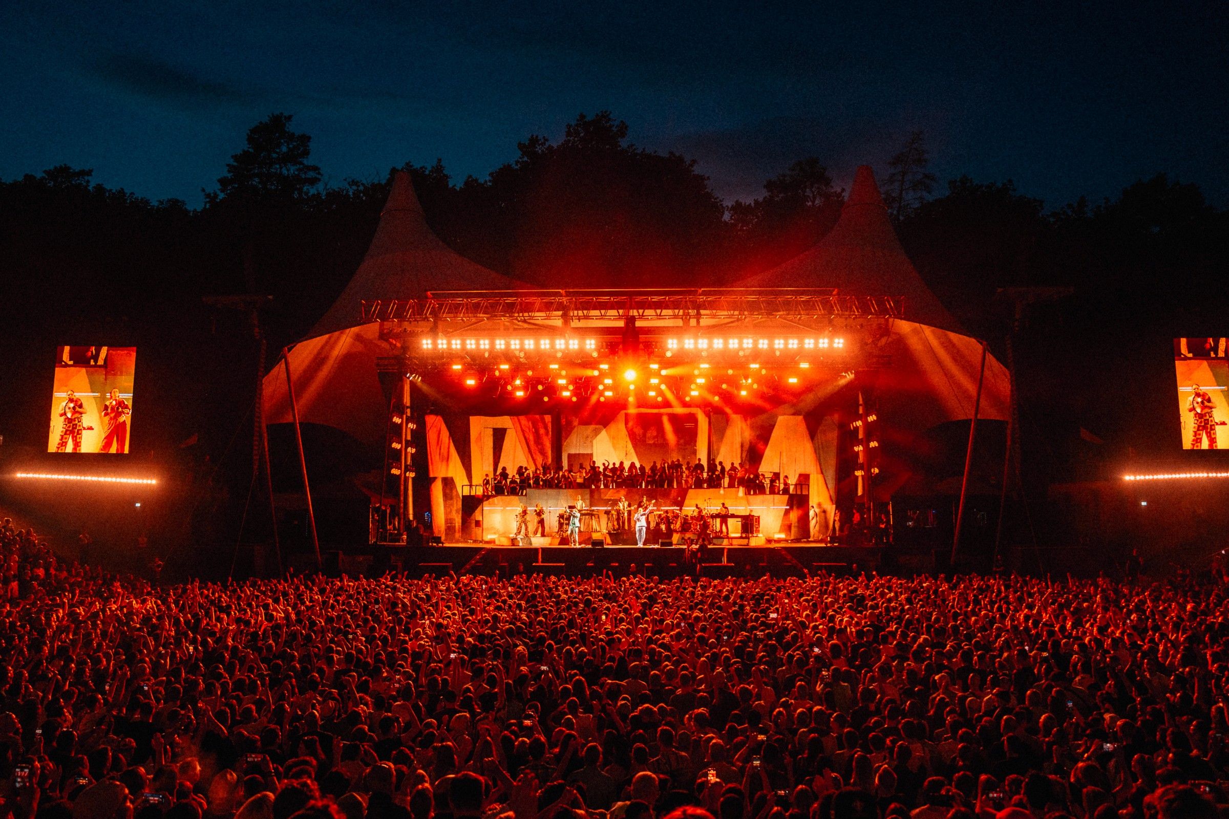 Peter Fox Tour: Open-Air-Bühne in rotem Licht vor großem Publikum