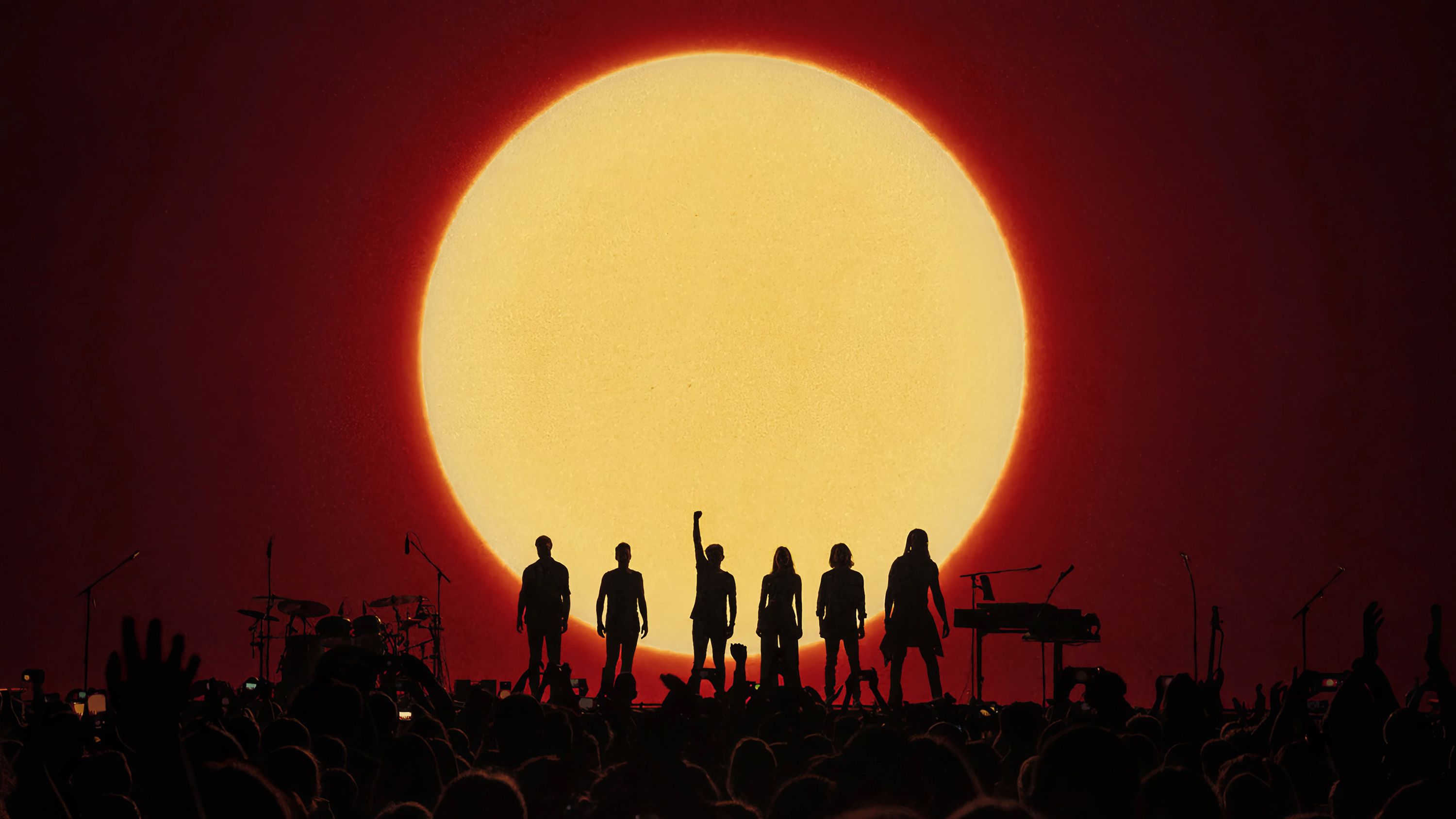 Michael Patrick Kelly B.O.A.T.S. Tour: Band als Silhouette vor einer riesigen leuchtenden Sonne