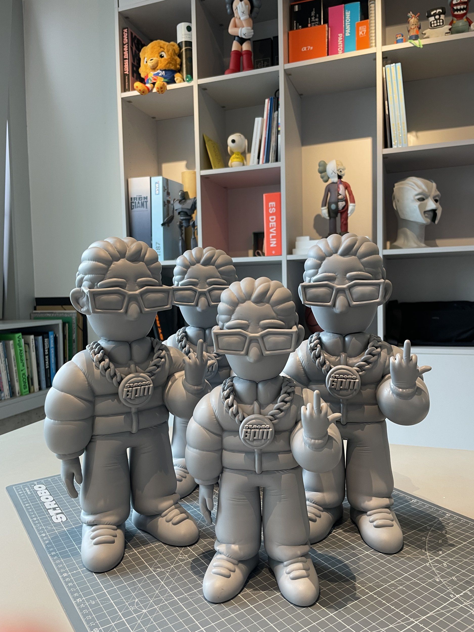 Graue 3D-gedruckte 6PM-Figuren in einem Studioregal