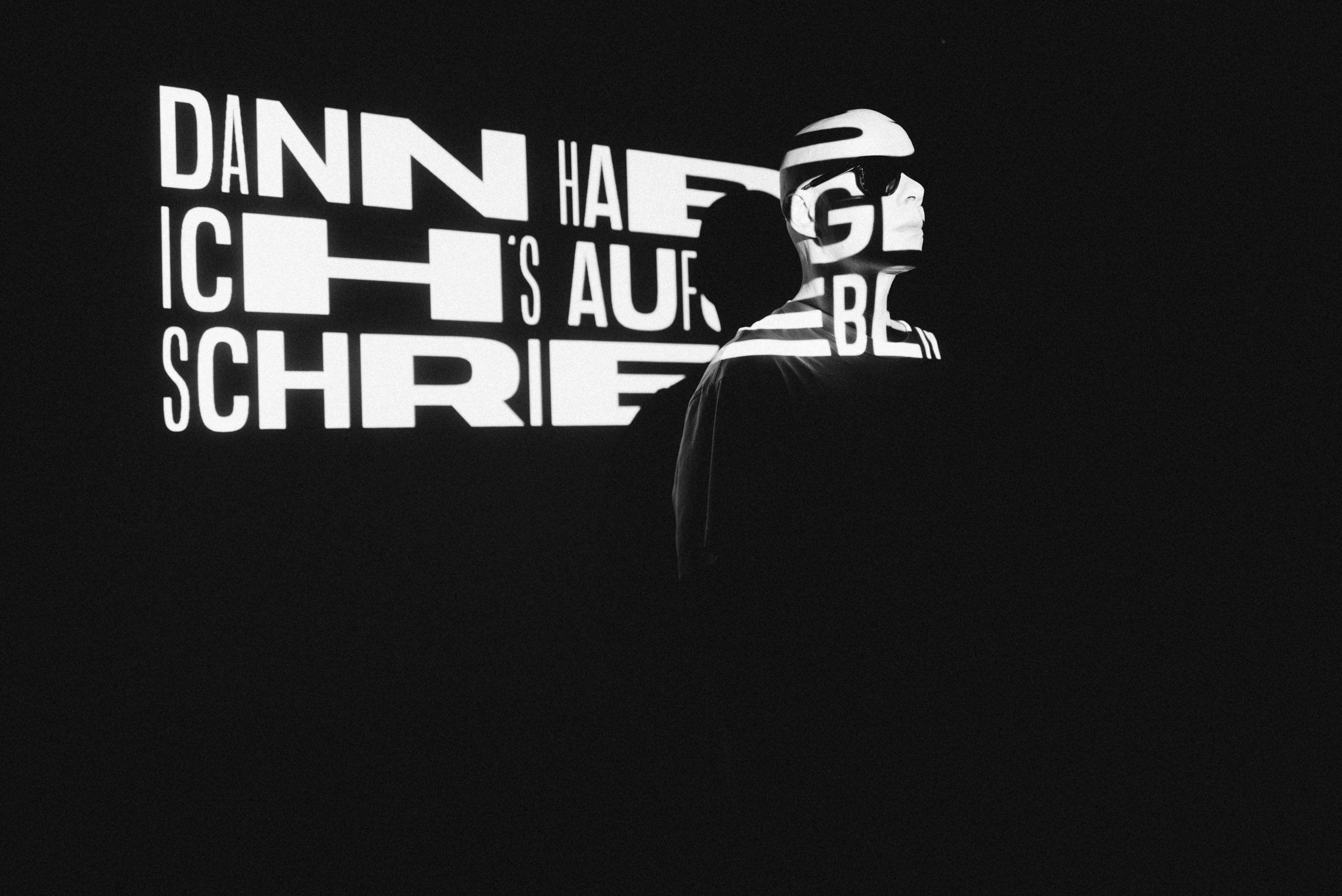 German lyrics projected as typography on the studio wall