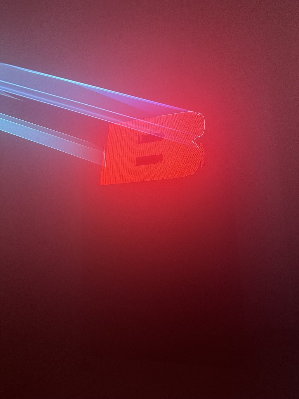 Laser beams tracing a red illuminated letter in fog