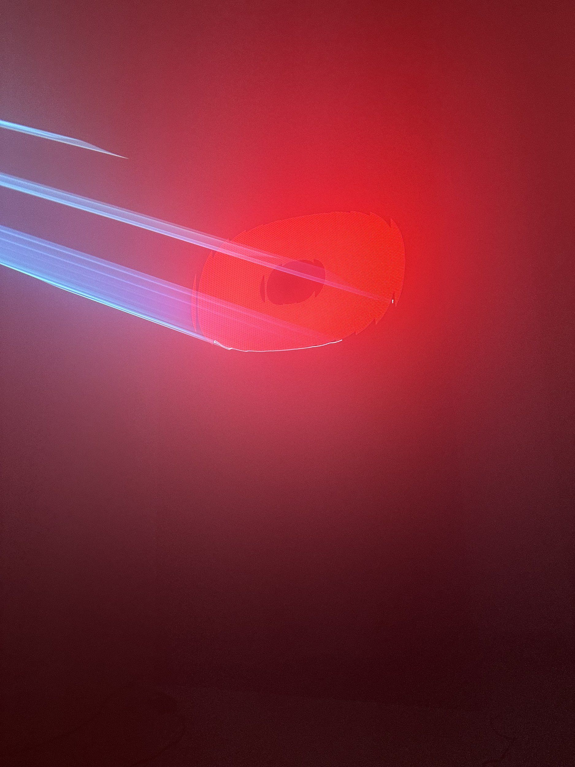 Close-up of a red letter lit by laser beams