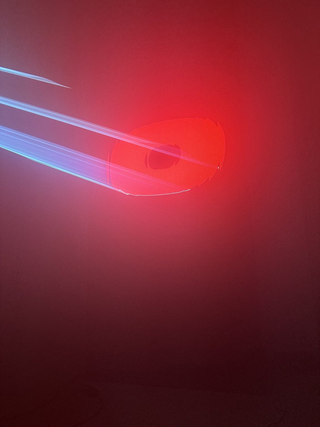 Close-up of a red letter lit by laser beams